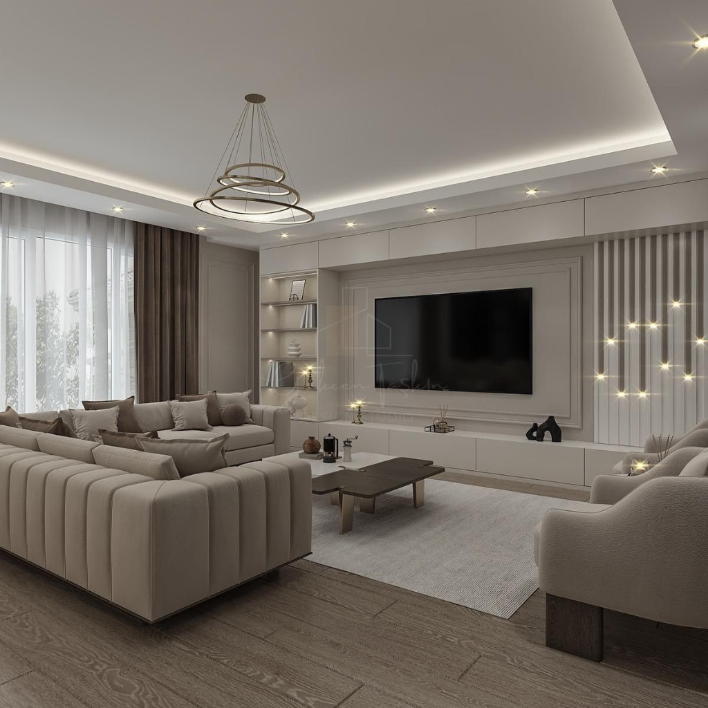 Modern living room with a beige sectional sofa, built-in TV wall, and a circular multi-ring chandelier in soft neutral tones.