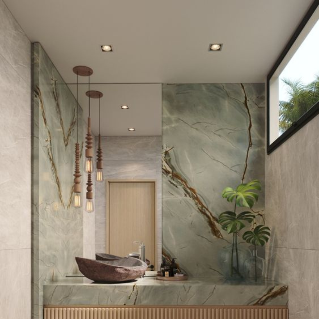 Luxurious marble bathroom with a vanity, vessel sink, and wooden slatted cabinet under a marble countertop; hanging pendant lights and a potted plant add greenery.