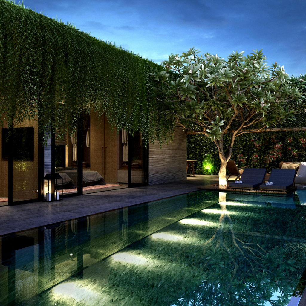 Luxurious backyard at dusk with a rectangular pool, glass-walled room, tall green hedge, and a tree casting reflections in the water.